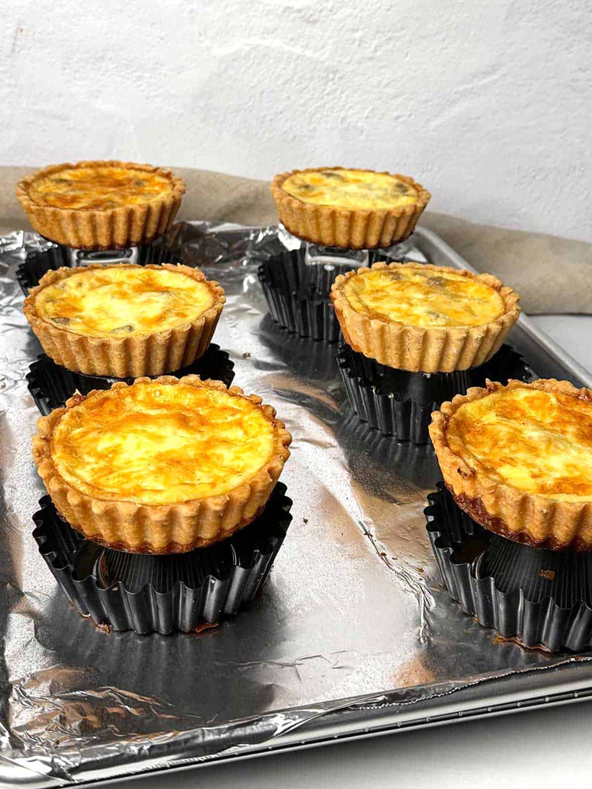 Cooling the mini quiches before serving.