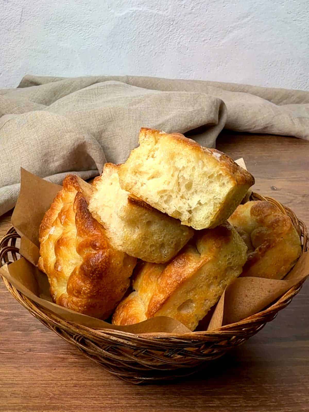 Mini focaccia loaves in a baskeet.
