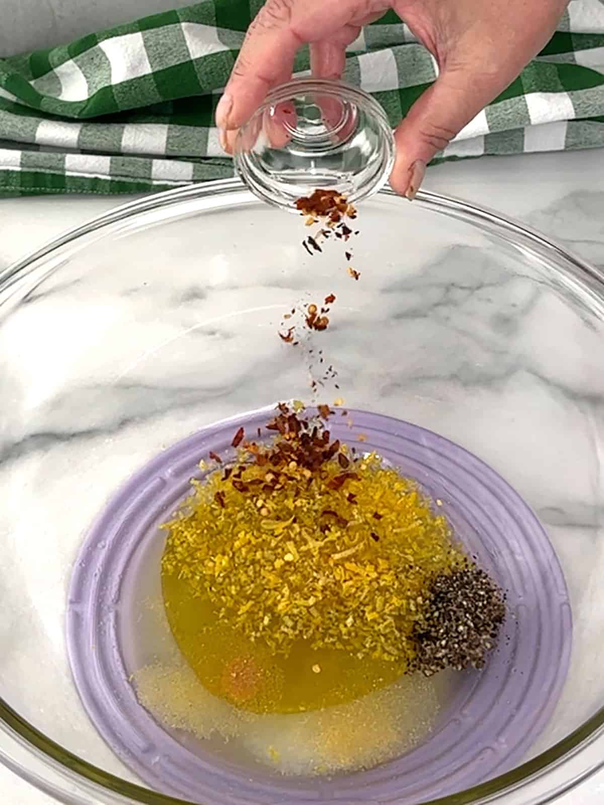 combining lemon juice, lemon zest, olive oil, salt, black pepper, garlic powder, onion powder, and red pepper flakes for dressing
