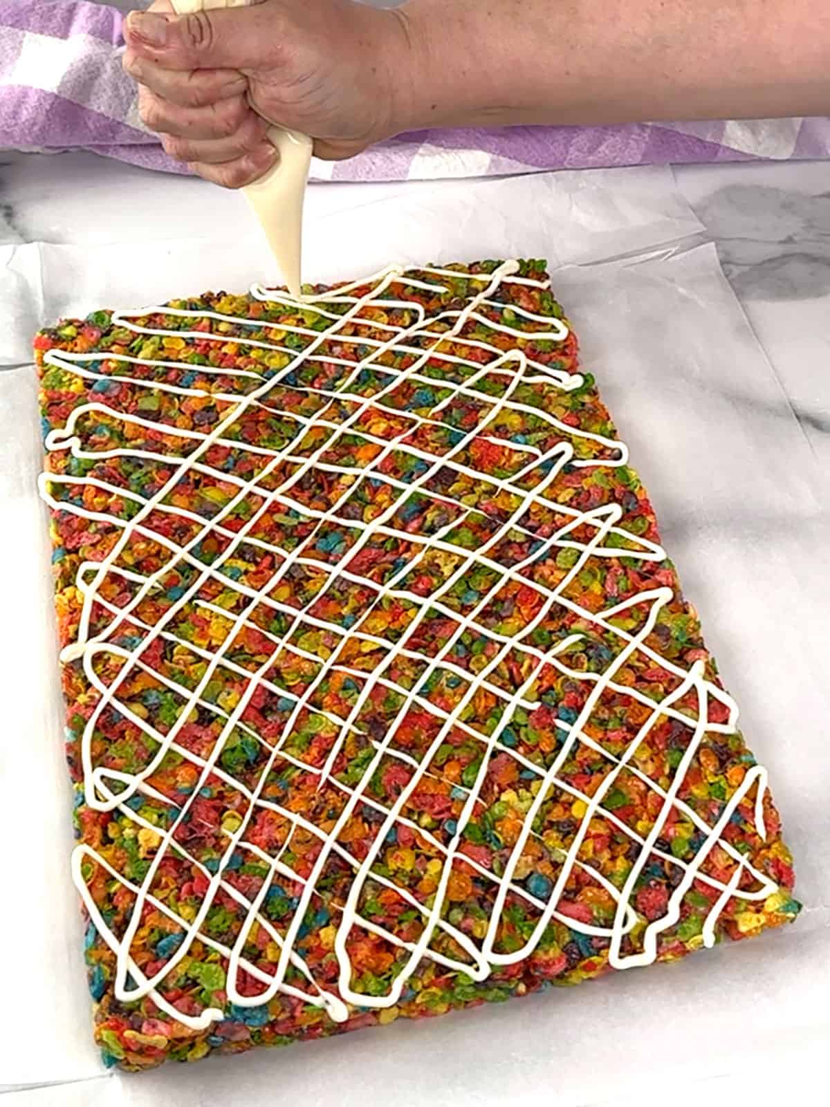 piping melted candy over fruity pebbles treats