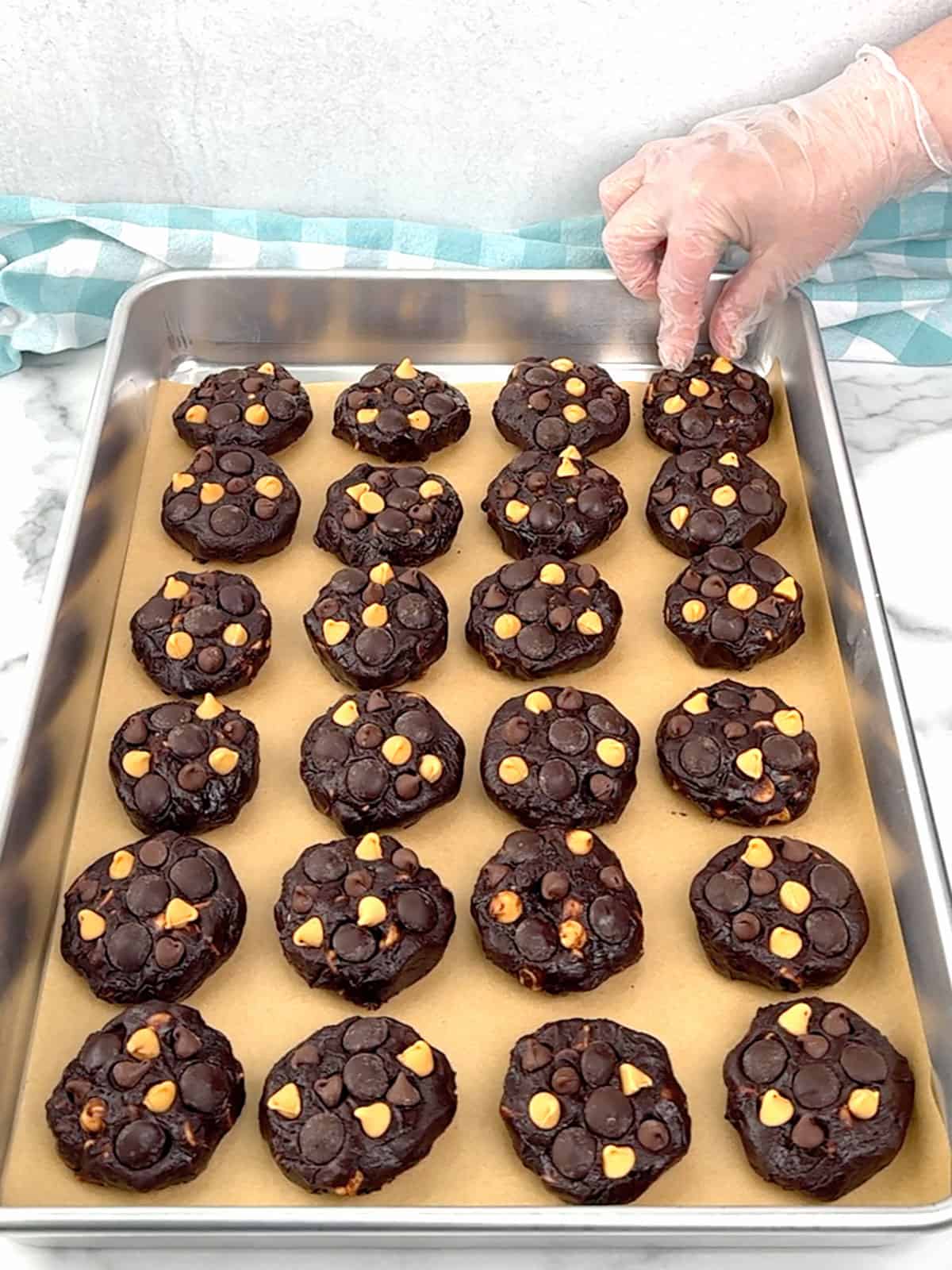 placing chips into the tops of flattened balls of dough