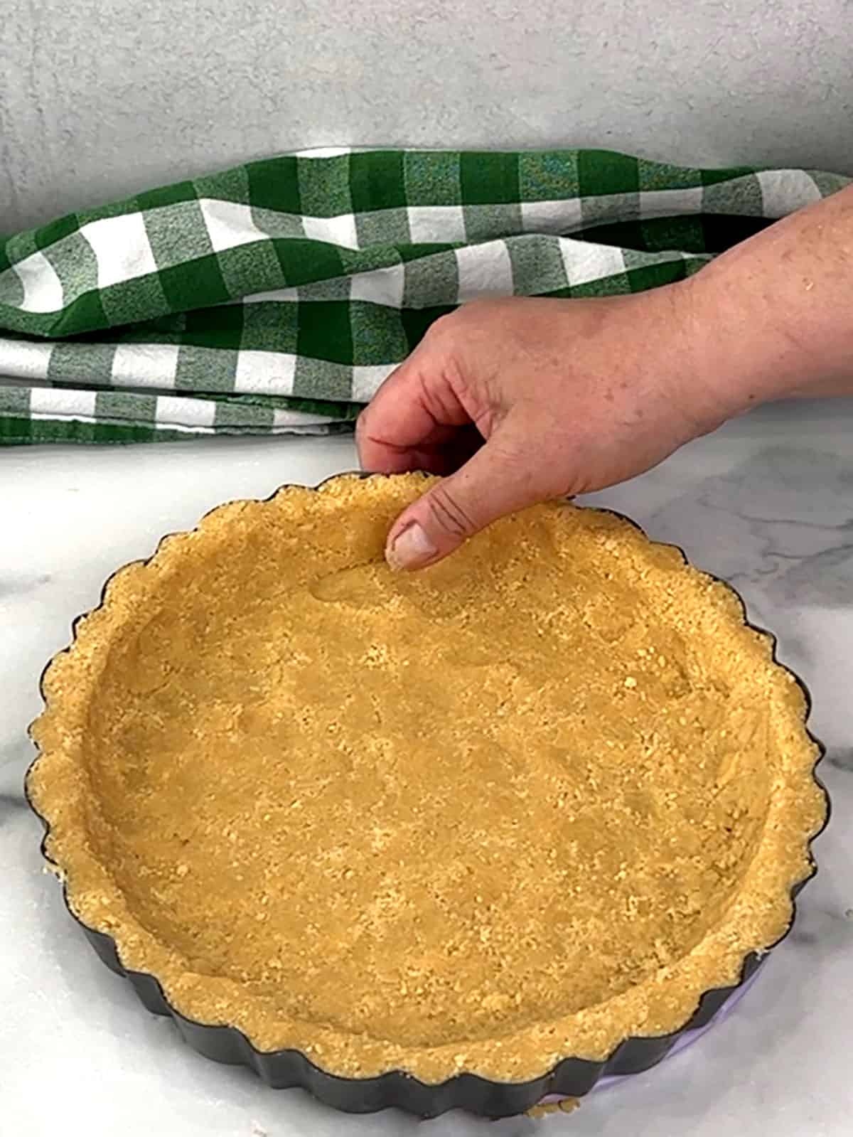 pressing crust into tart pan