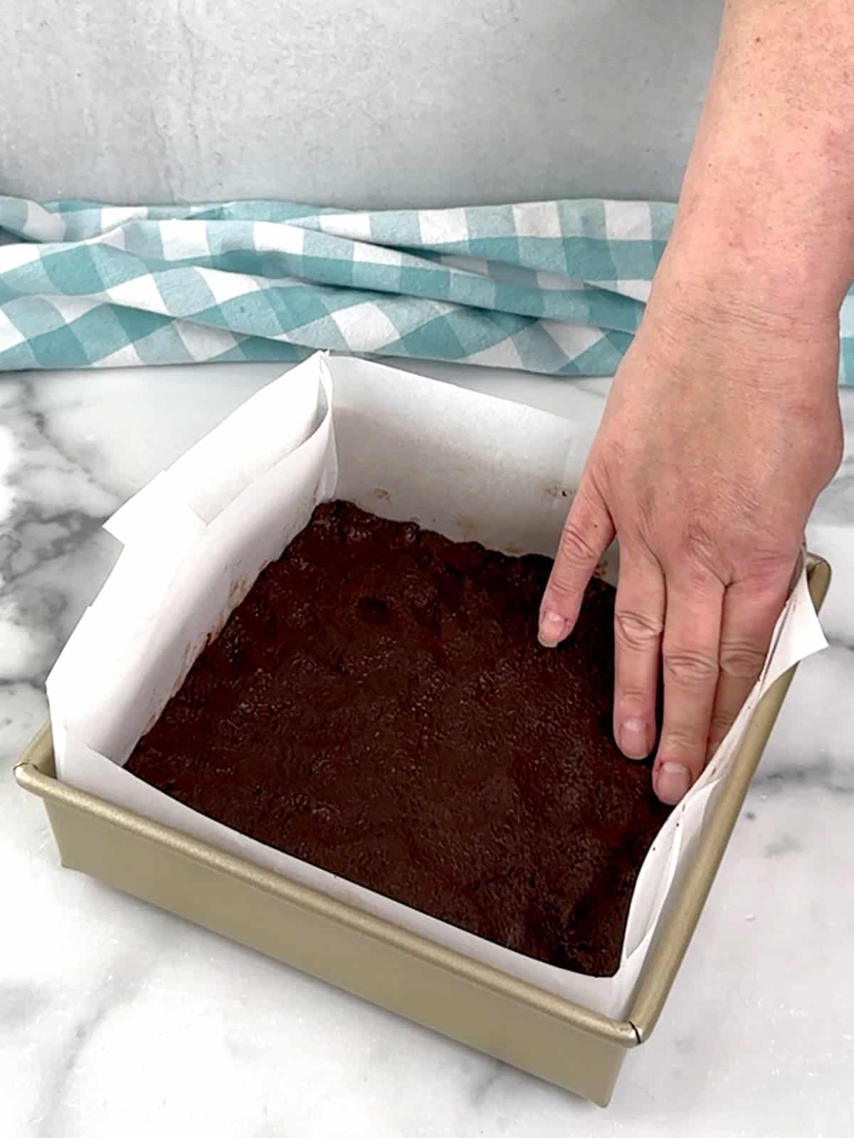 pressing crumbs into prepared pan