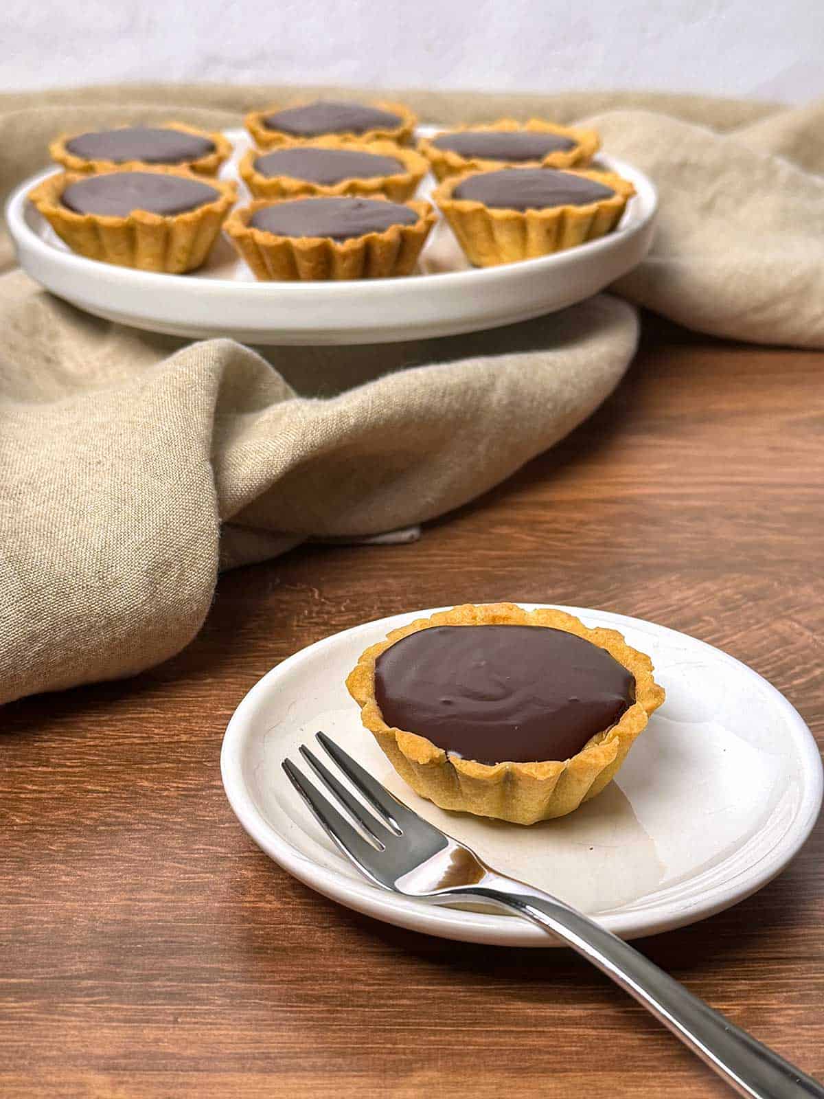 Mini chocolate peanut butter tarts with chocolate ganache.