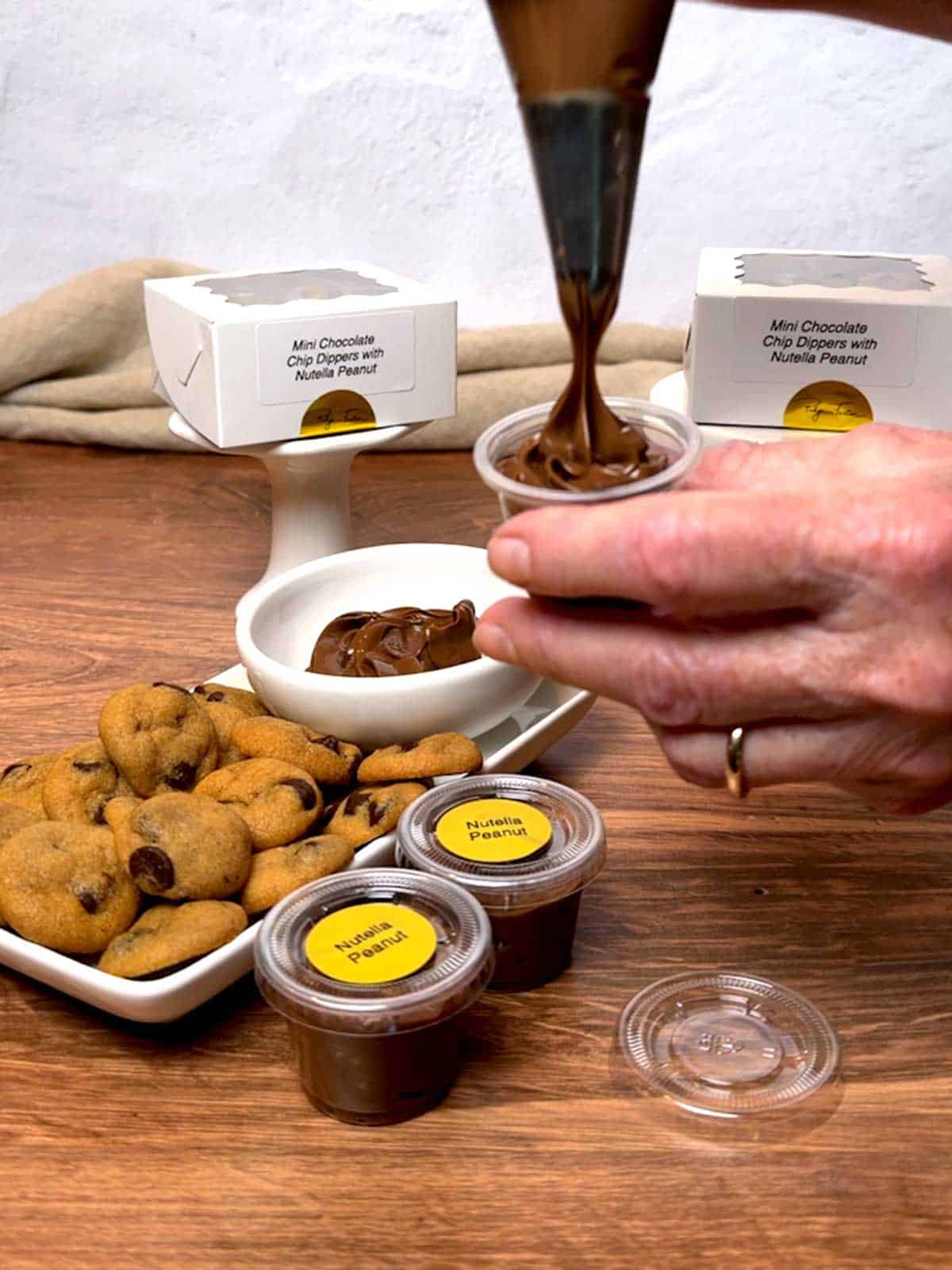 Piping the Nutella Peanut into the condiment cups.
