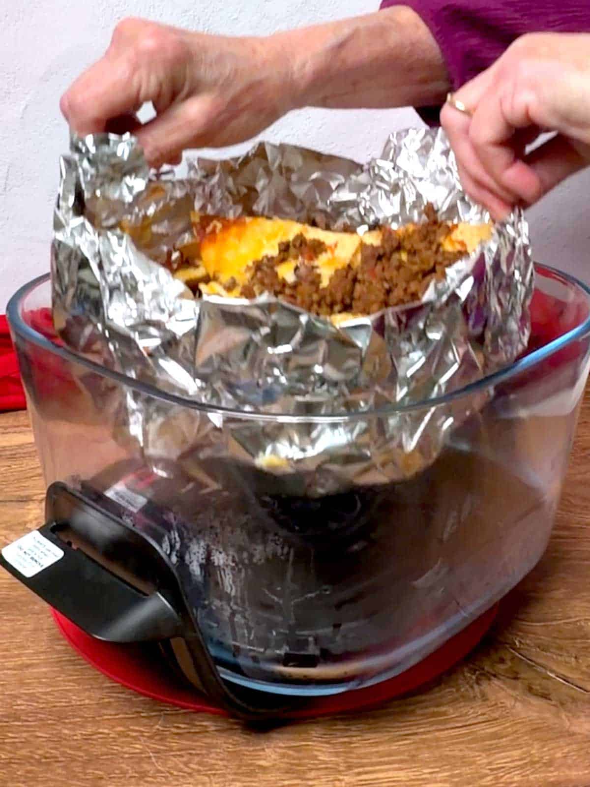 Removing the nachos from the air fryer basket.