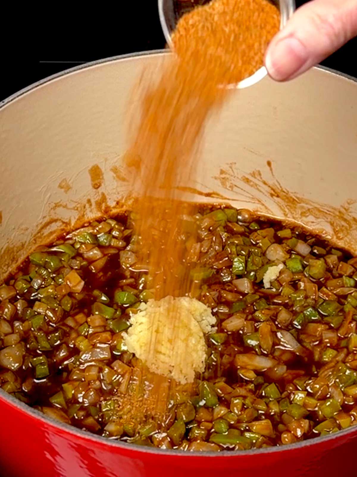 Adding Cajun seasoning to the cooking trinity with garlic added.