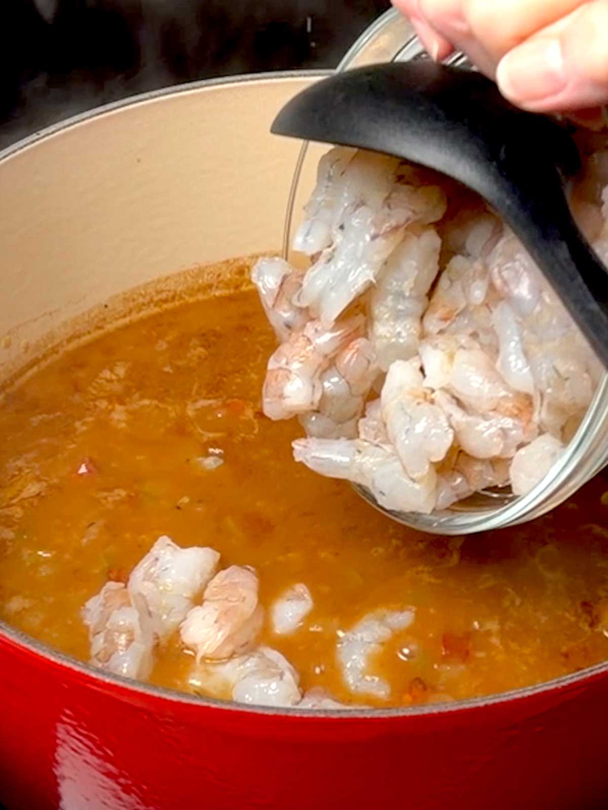 Adding the shrimp to the gumbo.