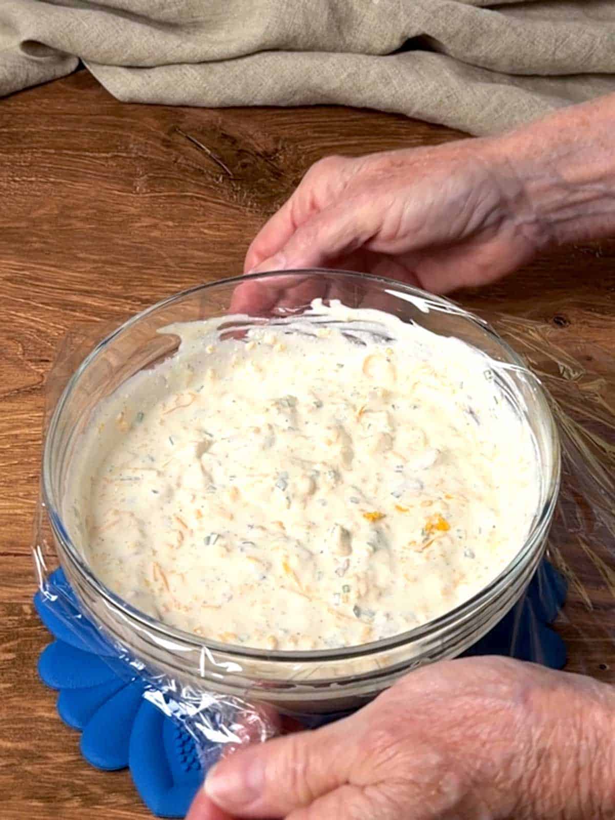 Covering the dip with plastic wrap.