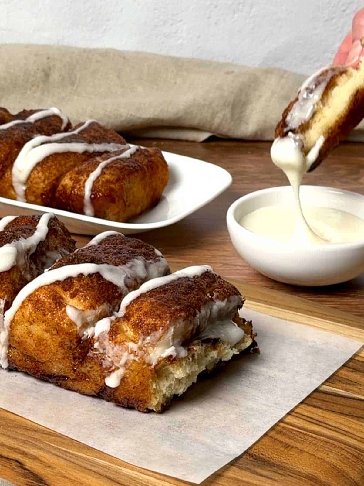 Dipping the cinnamon bread in icing.