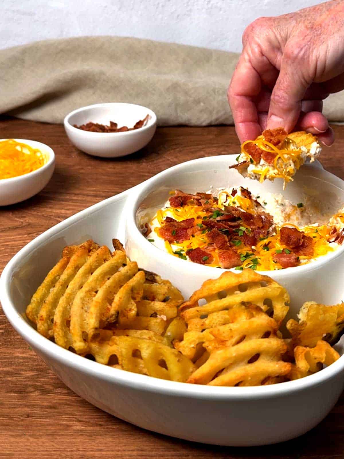 Dipping the waffle fry in the creamy dip.