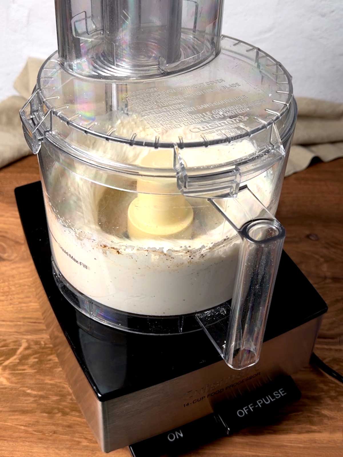 Processing cottage cheese, sour cream, hot sauce, and pepper in food processor.