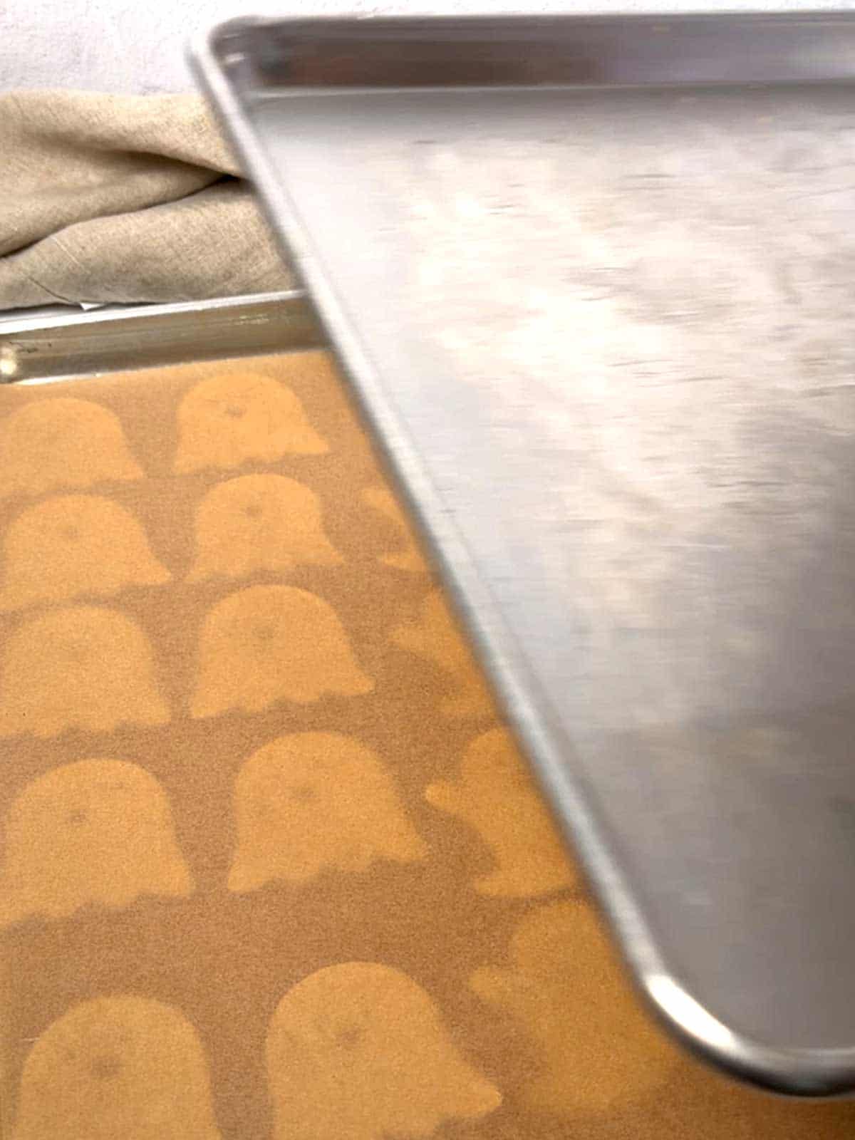 Placing the second sheet pan on the ghost cutouts.