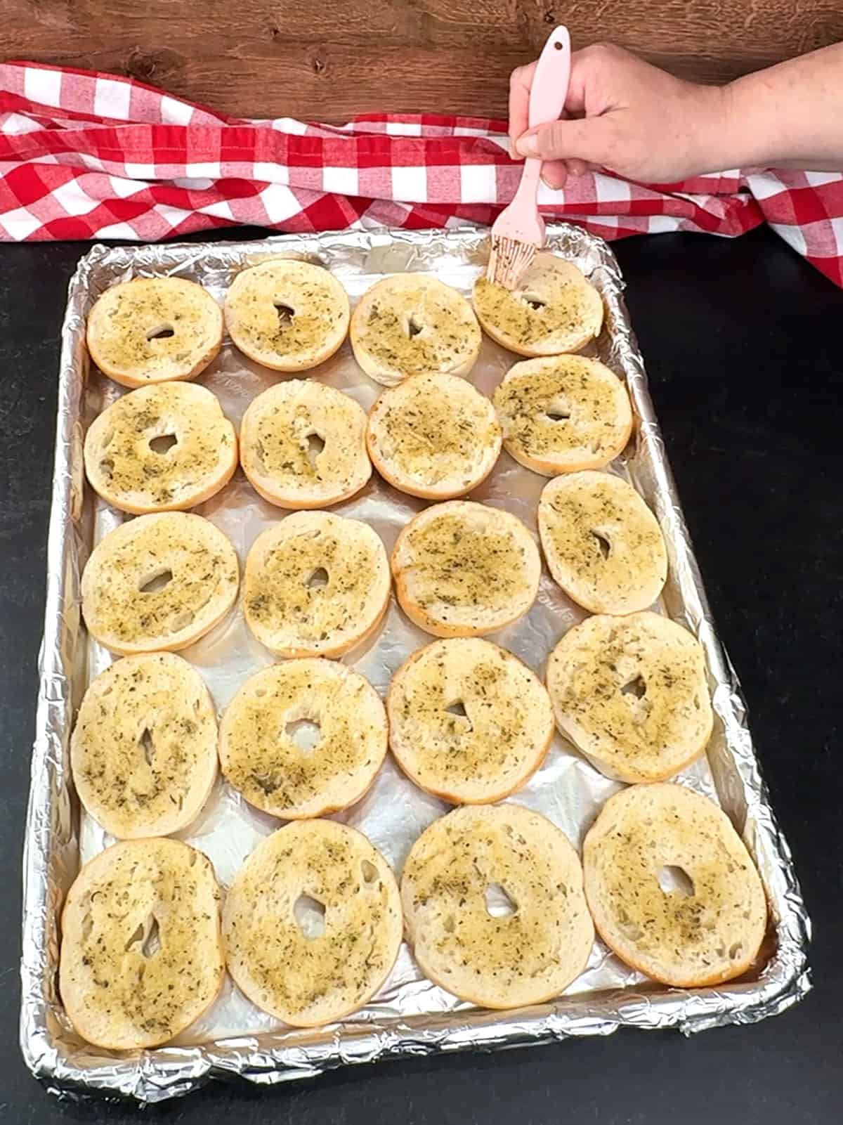 brushing tops of bagels with butter mixture