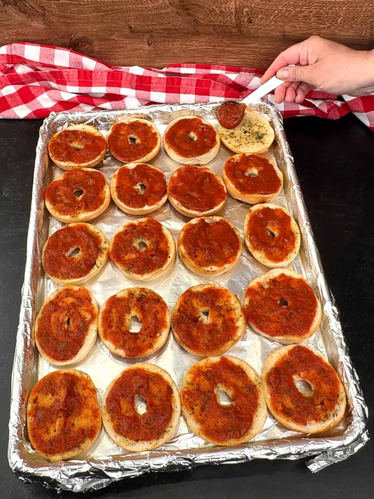 topping toasted bagel halves with pizza sauce