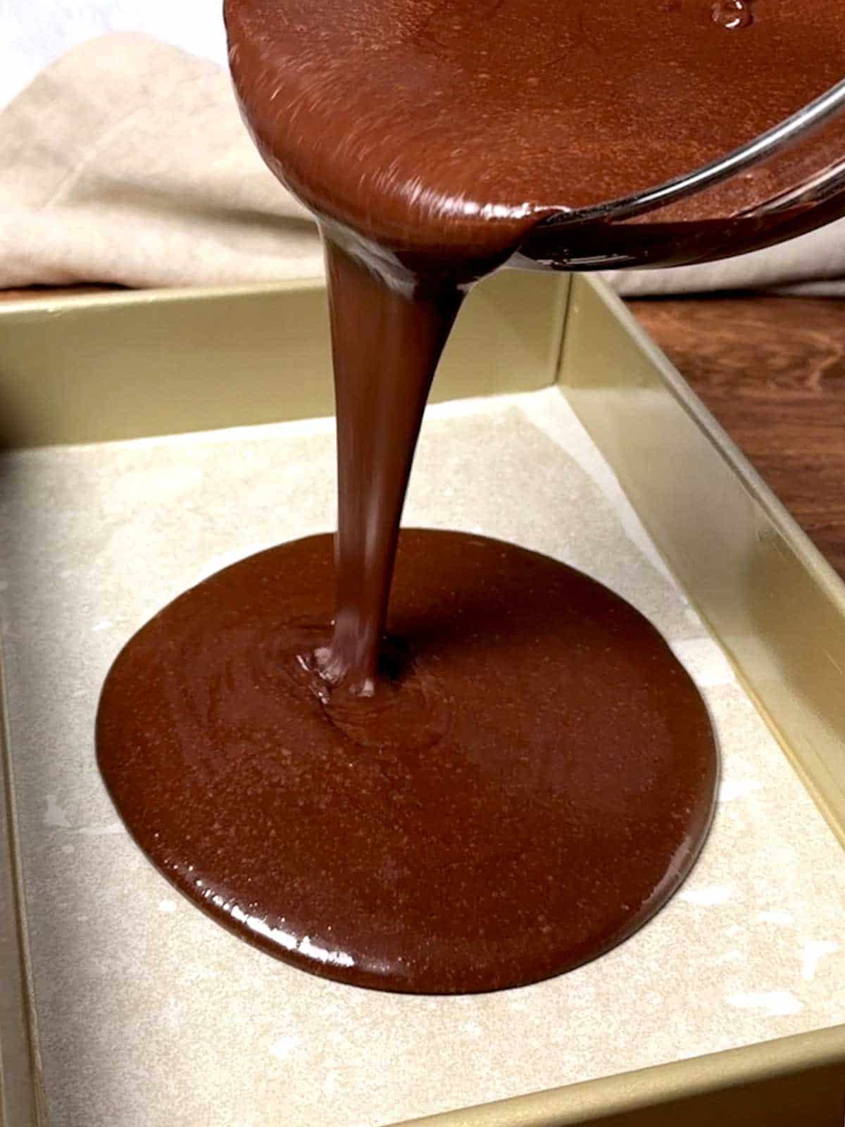Pouring the cake batter into the prepared baking pan.